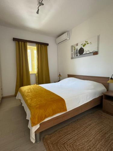 a bedroom with a large bed with a yellow blanket at Ardura shimmering on the sea in Mlini