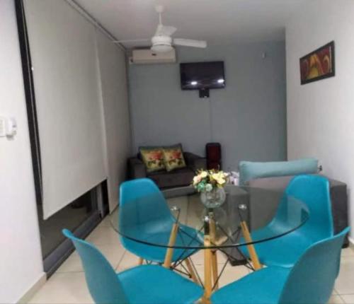ヴィラ・カルロス・パスにあるNGdeptosVCPのリビングルーム(ガラステーブル、青い椅子付)