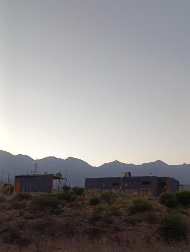 a train yard with mountains in the background at Tierra Andina Potrerillos in Potrerillos