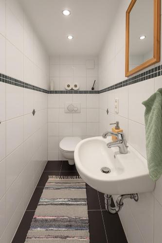 a white bathroom with a sink and a toilet at Gemütliche 2-Zimmer Wohnung 50qm in Reckershausen