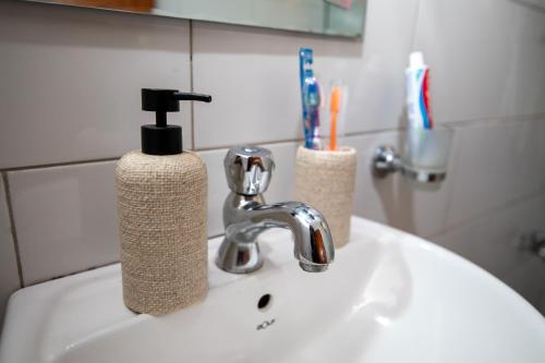 a bathroom sink with a toothbrush holder and a faucet at Kira Modern Elegance in Kampala