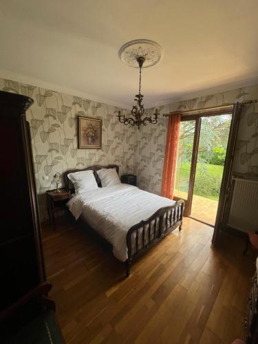 a bedroom with a bed and a chandelier at Maison village de Bigorre in Ossun
