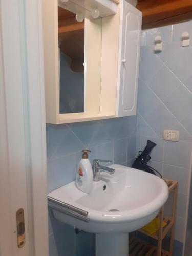 a bathroom with a white sink and a cabinet at Da Massimo in Cefalù