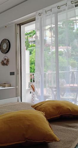 1 dormitorio con cama amarilla y ventana grande en Your favorite apartments, en Menton