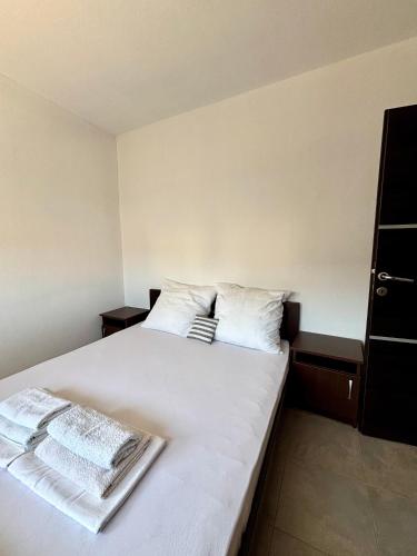 a bedroom with a white bed with two towels on it at Lotus in Donji Štoj