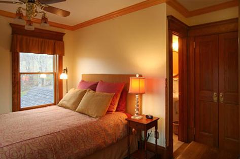 a bedroom with a bed with a lamp and a window at Breezy Hill Inn in Fleischmanns