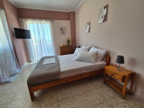 a bedroom with a bed with a television and a table at Lilia Apartments A1 in Vrahati