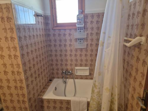a bathroom with a tub and a shower curtain at Lilia Apartments A1 in Vrahati