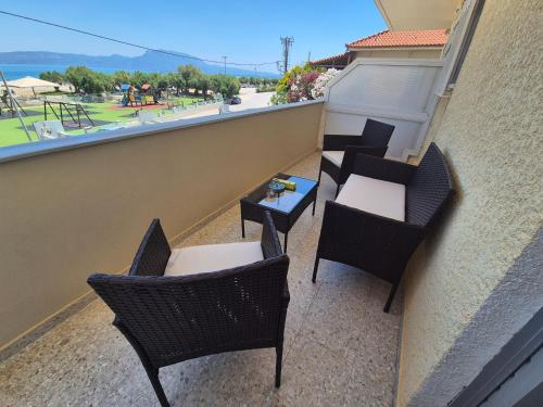 a balcony with chairs and tables and a playground at Lilia Apartments A1 in Vrahati