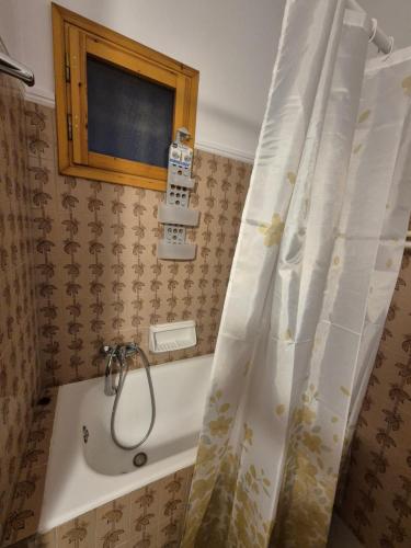 a bath tub with a shower curtain in a bathroom at Lilia Apartments A1 in Vrahati