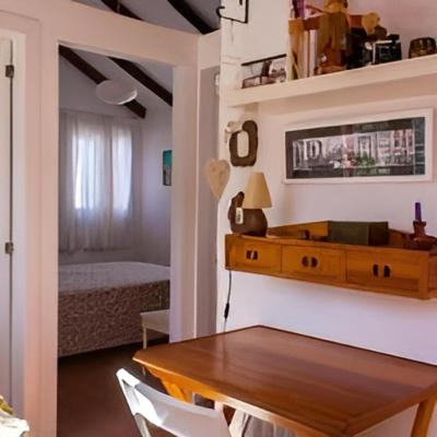 a dining room with a wooden table and a bedroom at La Casilla in Agaete