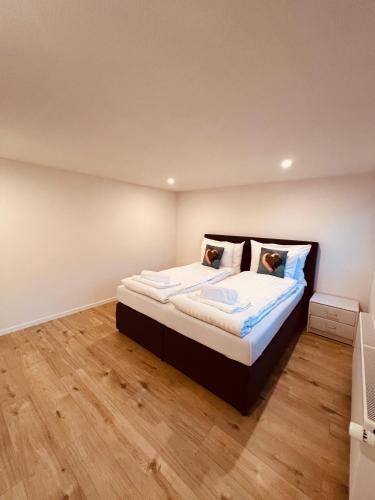 a bedroom with a bed with white sheets and pillows at Gemütliches Wohnung für Familien und Gruppen in Küblis