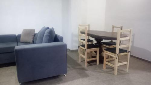 a living room with a blue couch and a table and chairs at Aire Urbano in Resistencia