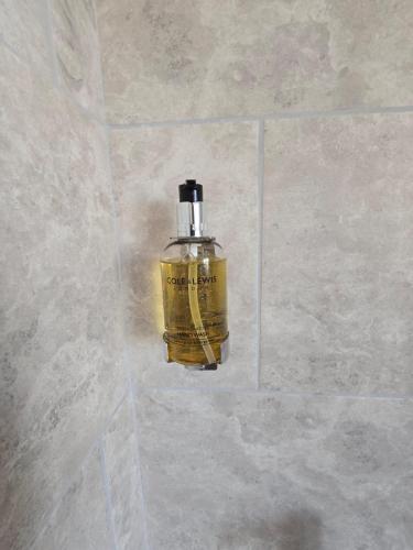 a bottle of oil sitting on a tile wall at Perfect Getaway 1 in Middlesbrough