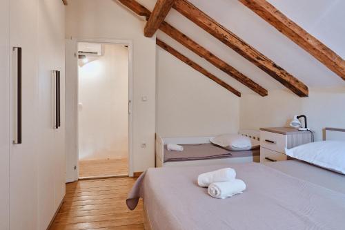 two beds in a room with wooden ceilings at Villa Dora in Omiš centar now with Jacuzzi in Omiš