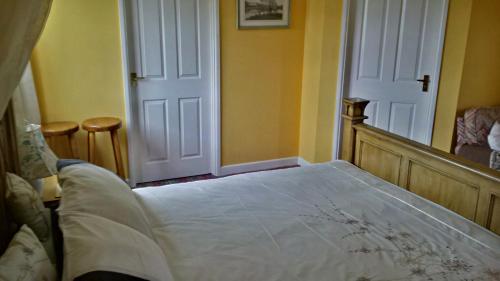 a bedroom with a white bed and a white door at Hethersett Lodge in Norwich