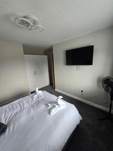 a bedroom with a white bed and a flat screen tv at Perfect Getaway 1 in Middlesbrough