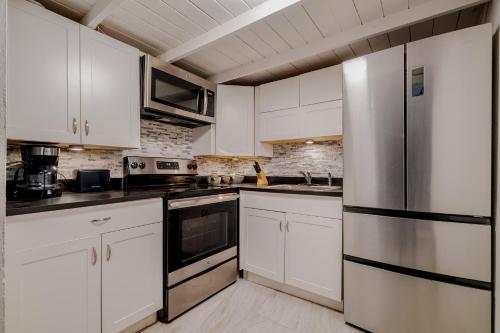 a kitchen with white cabinets and stainless steel appliances at Old San Juan Gateway Gem in San Juan