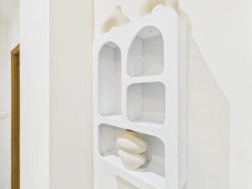 a white bookcase with white shelves in a white wall at Sweet stay T2 in Dreux