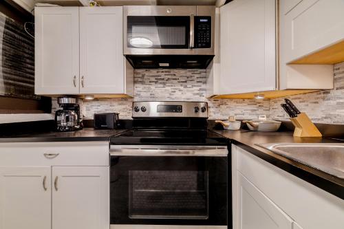 a kitchen with white cabinets and a black oven at Old San Juan Gateway Gem in San Juan