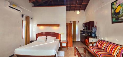 Tranquility Bay Resort في سان بيدرو: غرفة نوم بها سرير وأريكة