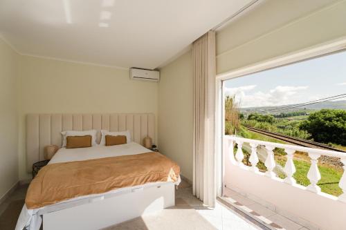 a bedroom with a bed and a large window at Casa do Carril - Private Pool - Douro Valley in Peso da Régua