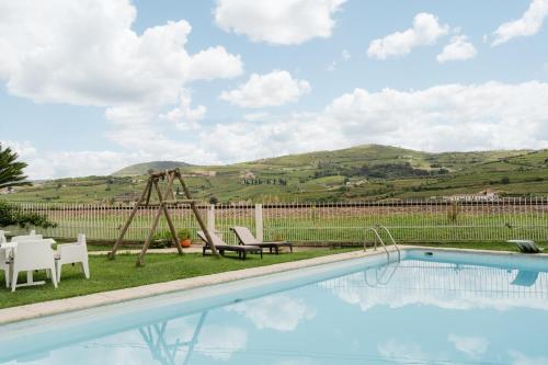 a pool with a table and chairs next to a field at Casa do Carril - Private Pool - Douro Valley in Peso da Régua