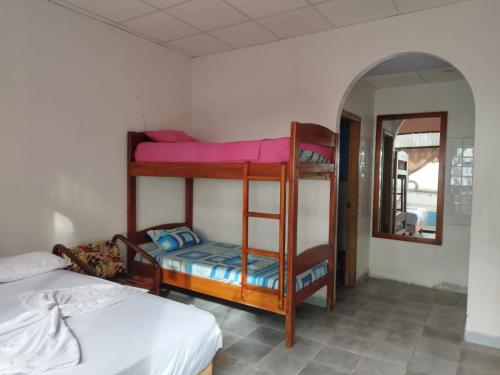 a room with two bunk beds and a mirror at RS Hotel Granada in Atacames