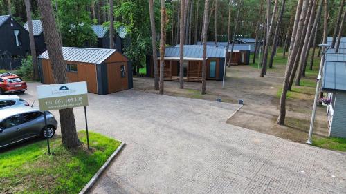 a sign in front of a park with some houses at Leśna Przystań in Pobierowo