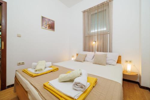 a bedroom with two beds with towels on them at Apartment Vlatka Grof in Selce