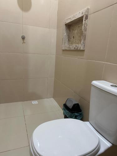 a bathroom with a white toilet and a shower at Hotel Manarela in Imperatriz
