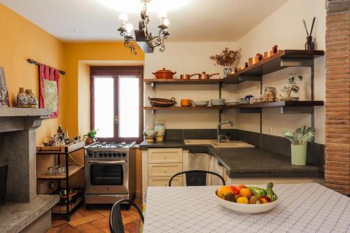 Una cocina con una mesa con un bol de fruta encima. en Casa Erica, en Lubriano