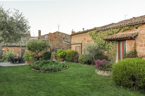 Un jardín en un antiguo edificio de piedra con un patio. en Casa Erica, en Lubriano