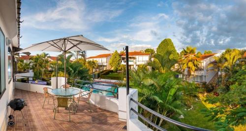 a balcony with a table and chairs and a pool at El paraiso en Melgar in Melgar