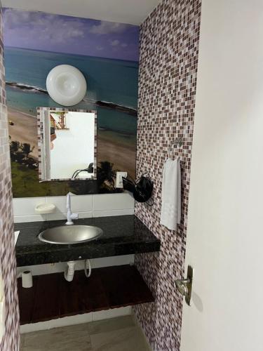 a bathroom with a sink and a mirror at Marinas Vista Mar in Tamandaré