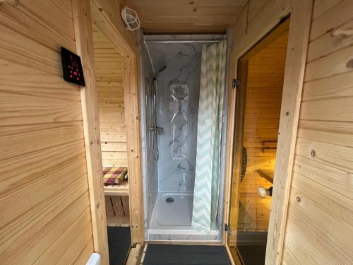 a walk in shower in a wooden room at Ferienhaus Gulfhof Tjaden in Großefehn 