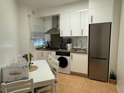a kitchen with a table and a stove and a refrigerator at Piso acogedor en Barbate in Barbate
