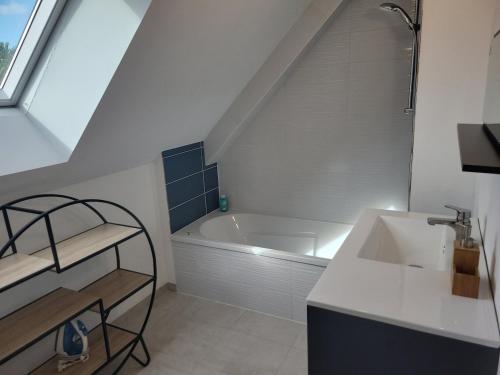 a bathroom with a sink and a bath tub at Maison Saint Philibert 3 chambres in Saint-Philibert