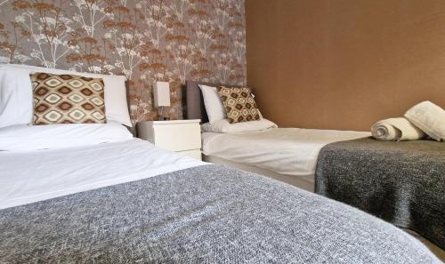 a bedroom with two beds and a wall at The Ransdale in Bridlington
