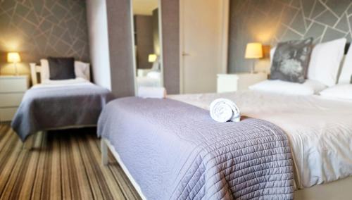 a hotel room with two beds with a clock on it at The Ransdale in Bridlington