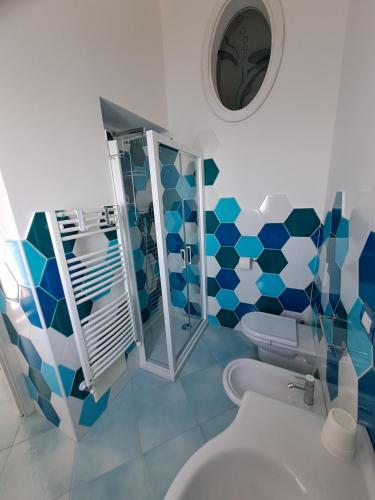 a blue and white bathroom with a toilet and a mirror at Casa Belle Vue in Furore