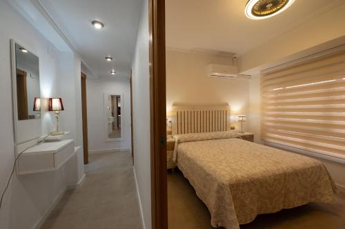 a small bedroom with a bed and a bathroom at Holiday Beach Centro in Santa Pola