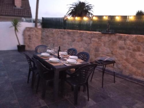 a wooden table with chairs and a bottle of wine at La Casita de Suances 2 Ideal Familias y Mascotas in Suances
