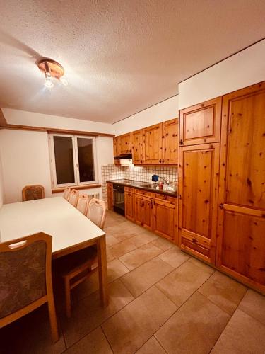 a kitchen with wooden cabinets and a table in it at Gemütliches und geräumiges Apartment für Familien und Gruppen mit Seeblick in Heiden