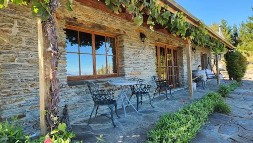 a patio with tables and chairs outside of a building at Creagh Cottage and Homestead in Arrowtown