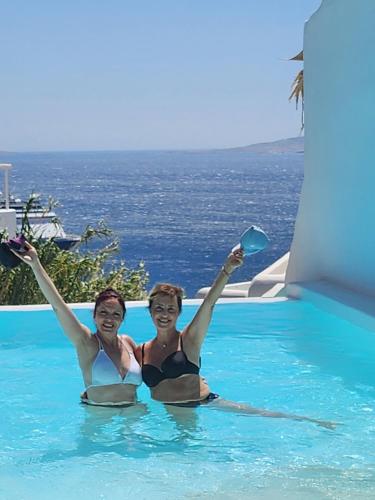 two women in the water in a swimming pool at ELLI TROPiCAL LUXURY SUITES SUNSET-INFINITY POOL- SEA SIDE-NEAR CENTER PARKING in Mikonos