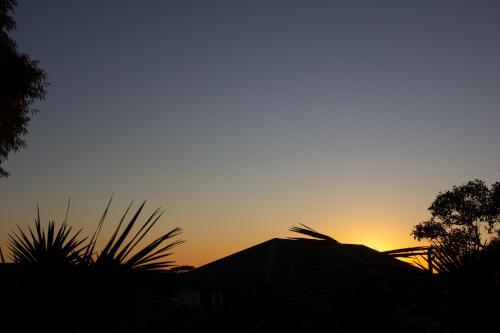 a sunset in the sky with a silhouette of a building at The Loft at Latitude 34 in Gnarabup