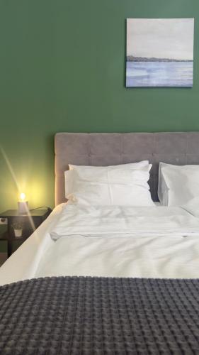 a large bed with white sheets and pillows at Code Srebrno Jezero in Veliko Gradište
