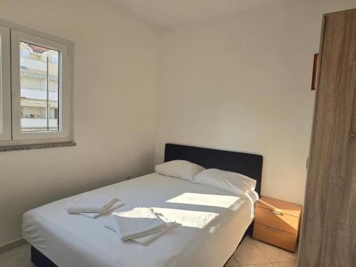 a white bed in a room with a window at Apartment Palma - Novalja in Novalja