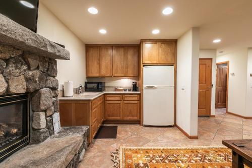 a kitchen with a stone fireplace and a refrigerator at Silver Rock Lodge home in Zephyr Cove